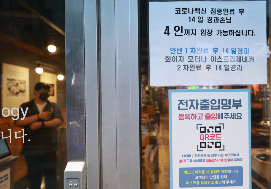 지난 14일 오후 저녁 장사를 앞둔 서울 종로구의 한 식당 입구에 방역패스(백신접종증명·음성확인제) 관련 안내문이 부착돼 있다. 서울행정법원 행정4부(한원교 부장판사)는 이날 조두형 영남대 의대 교수와 의료계 인사들, 종교인 등 1023명이 서울시장을 상대로 낸 집행정지(효력정지) 신청을 일부 인용했다. 이 결정으로 서울 내의 방역패스를 3000㎡ 이상 상점·마트·백화점에 적용한 조치의 효력이 정지된다. 12∼18세 청소년에 대해선 17종의 시설 전부에서 방역패스의 효력이 정지된다  법원은 마트, 백화점 등은 필수 이용 시설로 출입 통제는 과도한 제한이라고 판단했다. 반면 식당, 카페 등의 방역패스는 현행 유지된다. <연합뉴스>